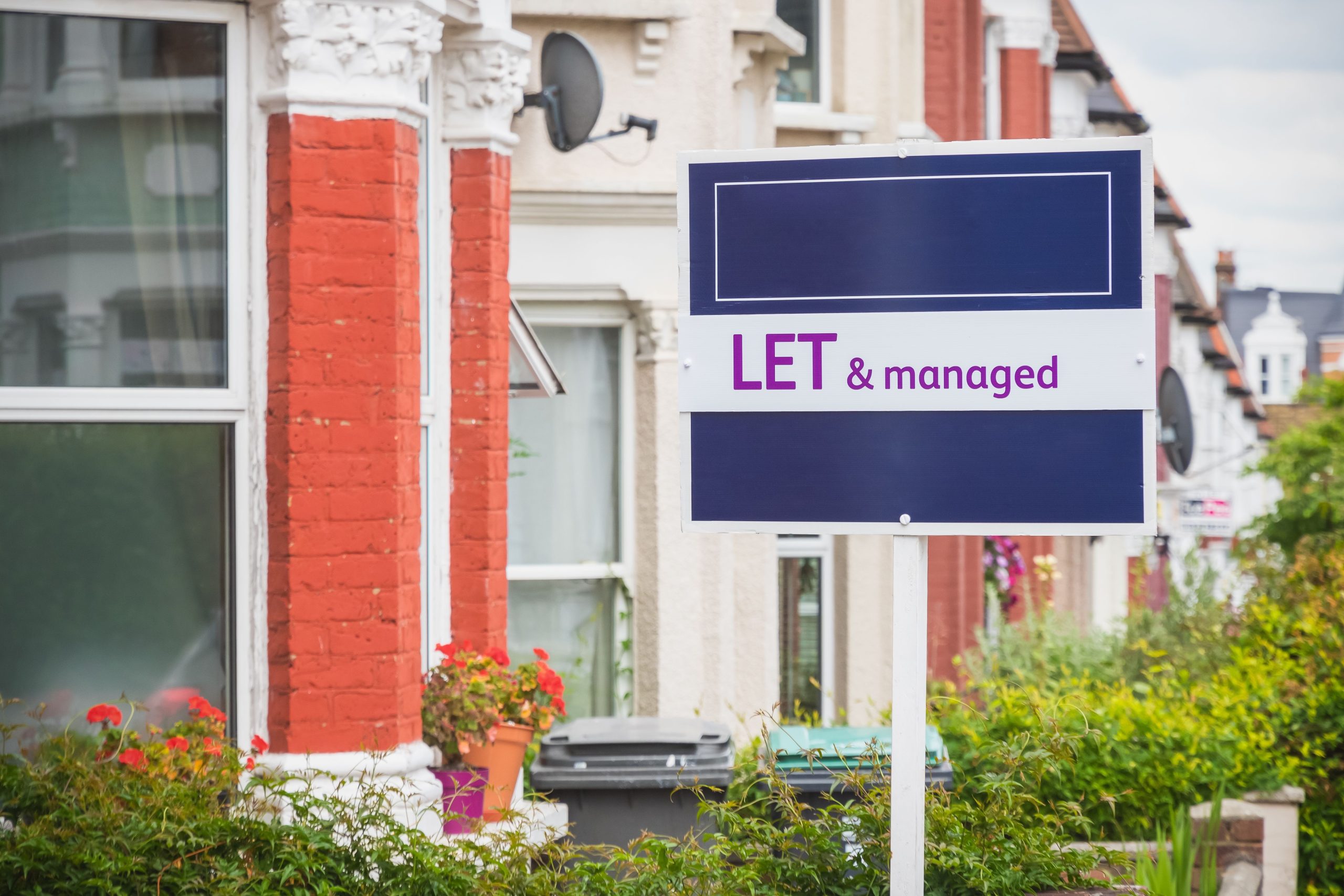 Estate agent sign displayed outside a terraced house in London