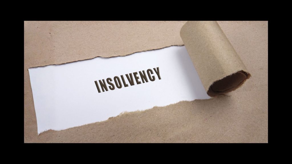 brown envelope ripping open to reveal the words insolvency in capitals