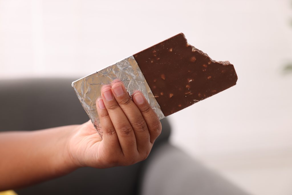 close up of child's hand holding a chocolate bar