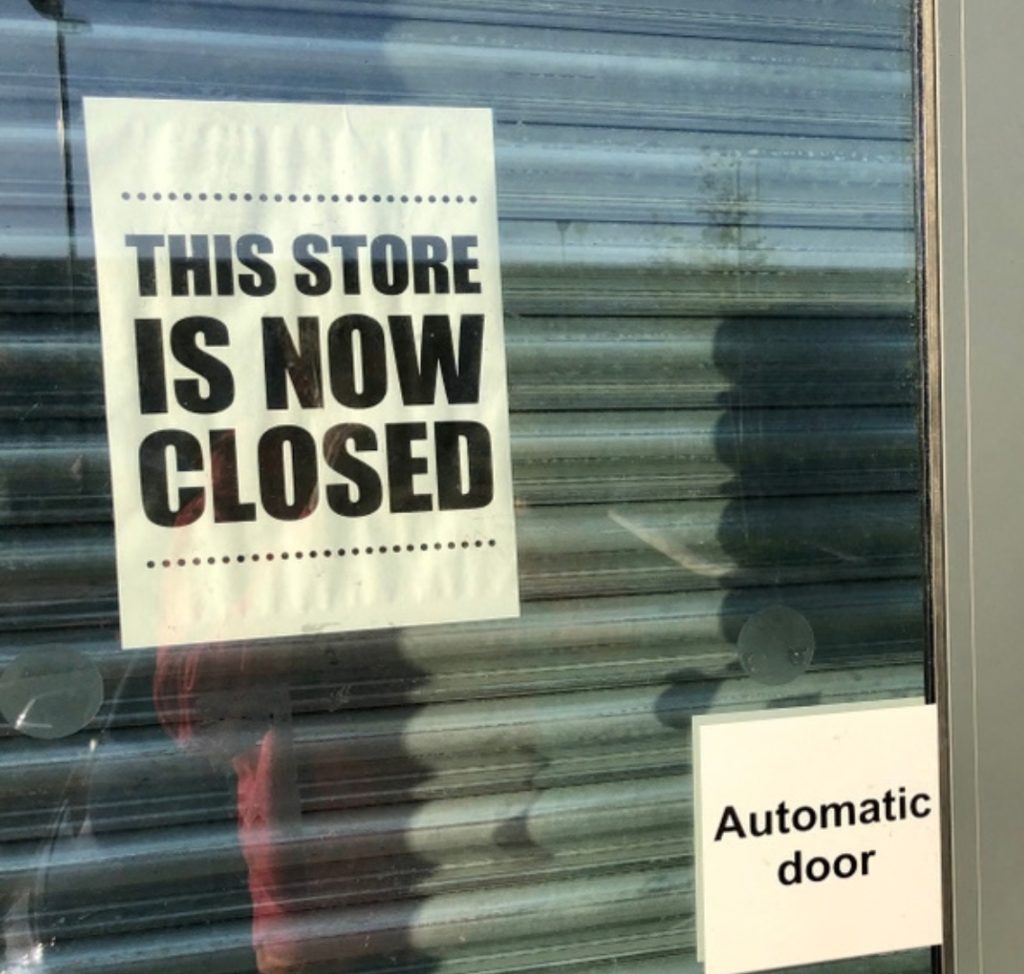 front of uk glass shop doors showing 'this shop is now closed' signs